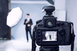 man getting headshot in suit, looking from the back of the camera