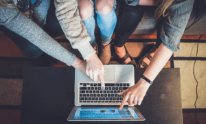 girls pointing at website