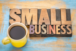 colored wood that reads small business next to a cup of coffee